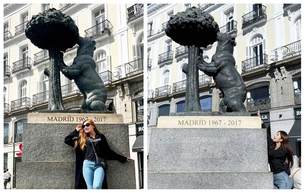 Cheerful female tourist posing playfully with the famous Madrid bear statue